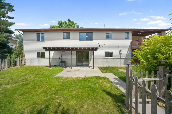 Rear of home, basement entrance thru covered patio,  upper-level balcony, and a fenced yard