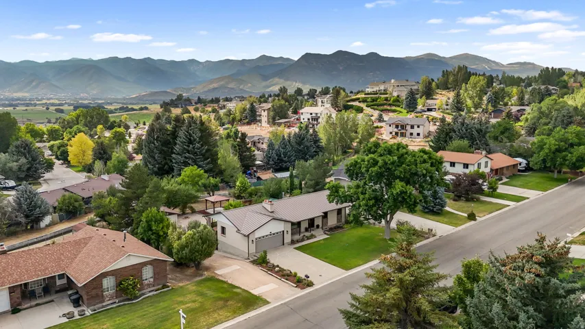 Expansive aerial view showcasing this residential property nestled within a verdant valley landscape