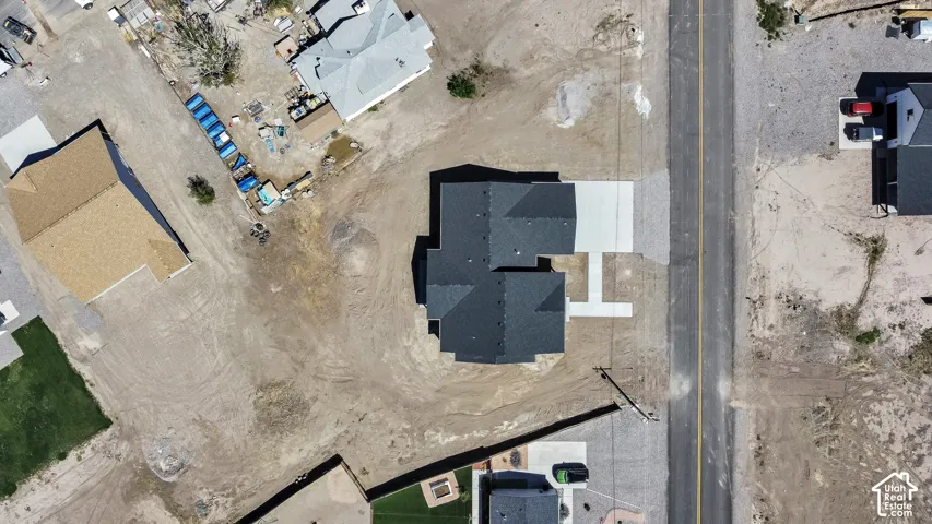 New construction residence with dark shingle roofing, concrete driveway, and direct road frontage
