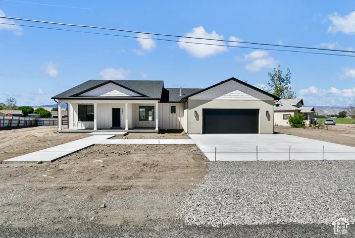 Single-story residence featuring a covered front porch with columns, a two-car garage, and a concrete driveway