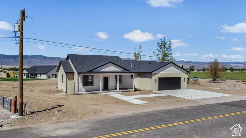 Contemporary ranch exterior with a covered front porch, attached garage, and concrete driveway
