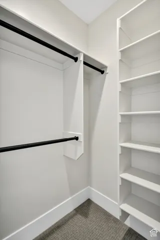 Custom closet organization system featuring multiple hanging rods and extensive shelving