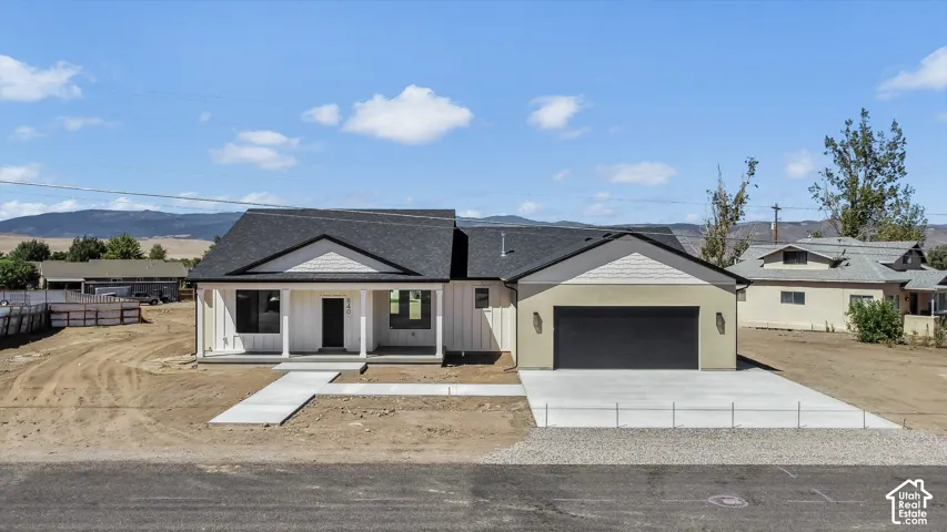 Contemporary ranch-style exterior with a covered porch, board and batten siding, horizontal siding accents, and an attached two-car garage