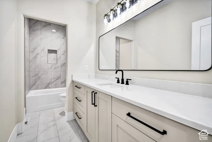 Spacious vanity with light-toned cabinetry, white countertop, and matte black fixtures