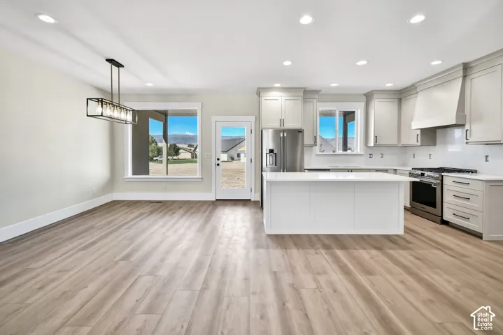 Kitchen featuring a center island, stainless steel appliances, light-toned cabinetry, and recessed lighting