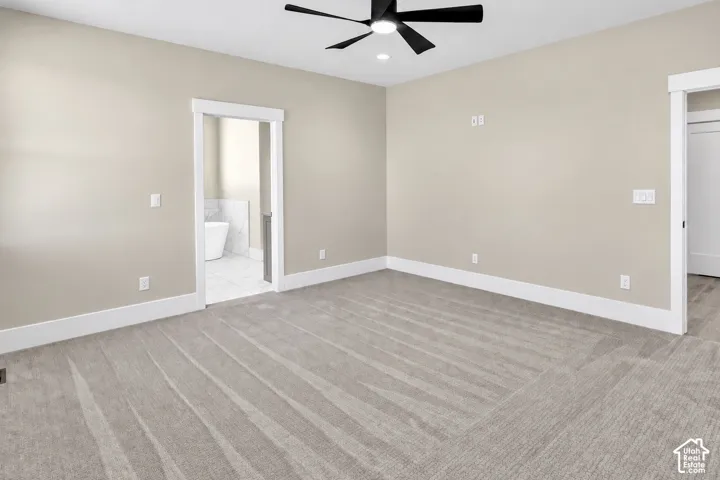 Neutral-toned carpeted flooring throughout, crisp white trim, and a ceiling fan with integrated lighting