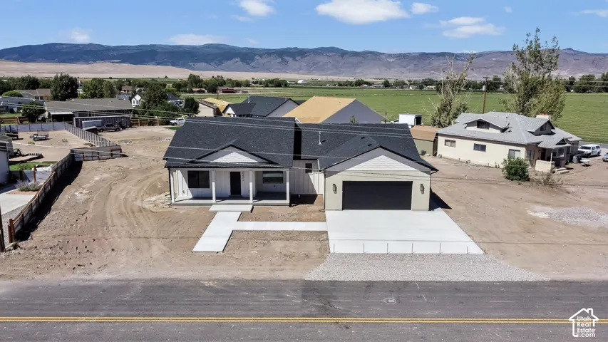 Newly constructed residence with a dark shingle roof, white siding, and an attached two-car garage