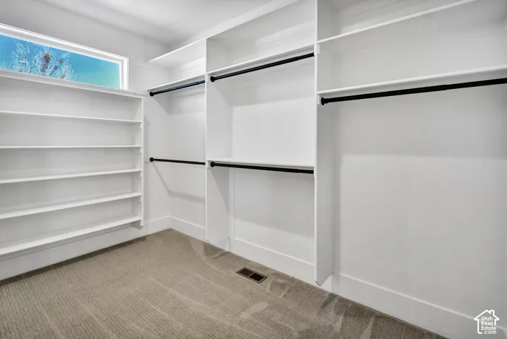 Built-in shelving, multiple hanging rods, and a high window