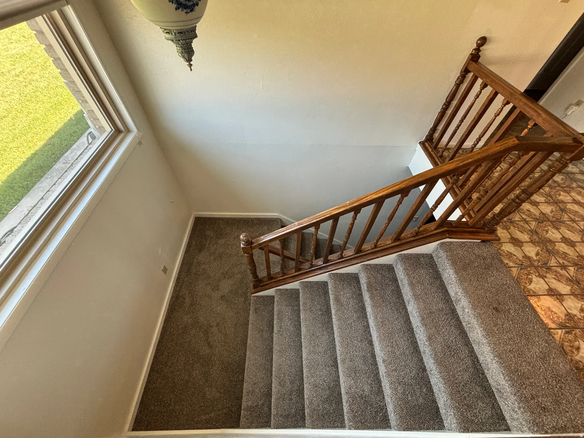 Carpeted staircase with wood banister and balusters