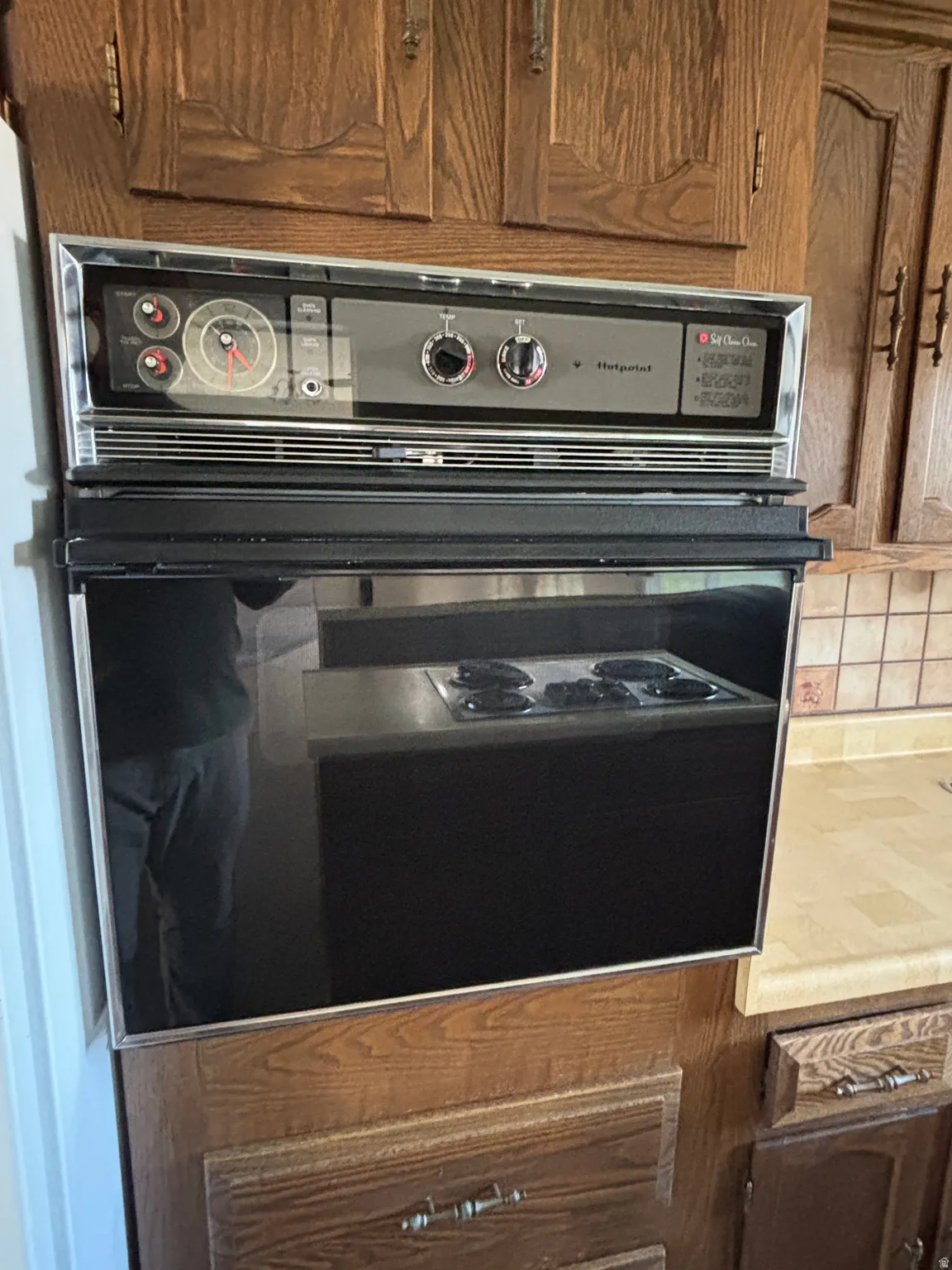 Built-in wall oven with a contrasting dark glass door and integrated controls