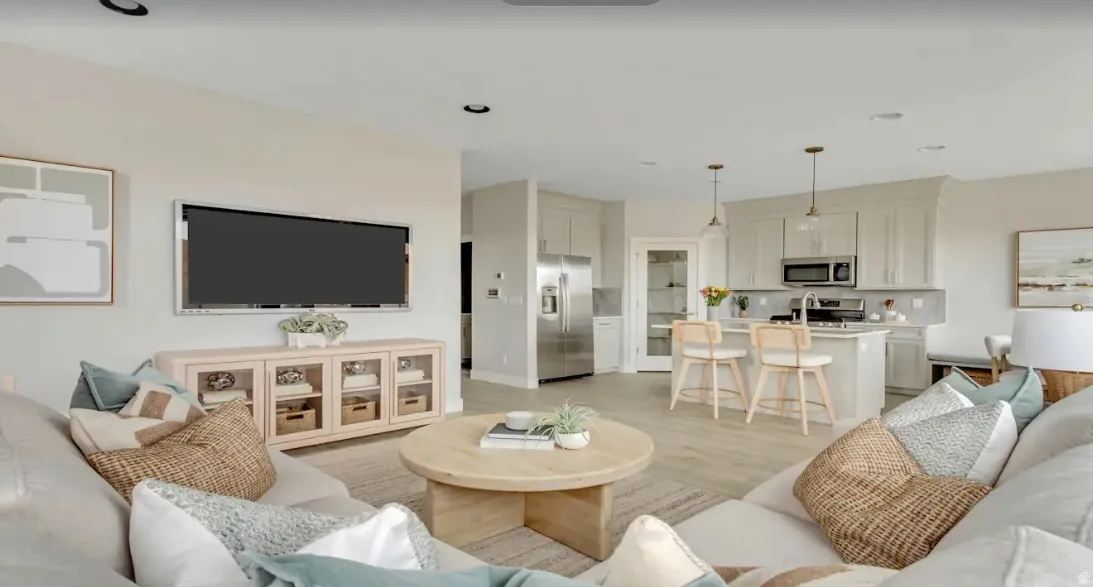 Open-concept living space featuring wood-finish flooring. This home is under construction. Pictures are of a similar home.