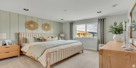 Feature wall with vertical paneling, recessed lighting, expansive window, neutral carpeting, and wood-finish dresser. This home is under construction. Pictures are of a similar home.
