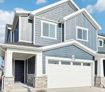 Two-story exterior with multi-toned siding, stone accents, covered entry, and an integrated garage. This home is under construction. Pictures are of a similar home.