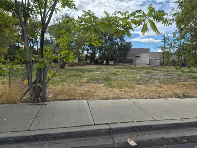 Expansive lot featuring mature trees and a chain-link fence