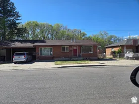 Brick-clad exterior with a covered carport, pitched roofline, and front-facing windows