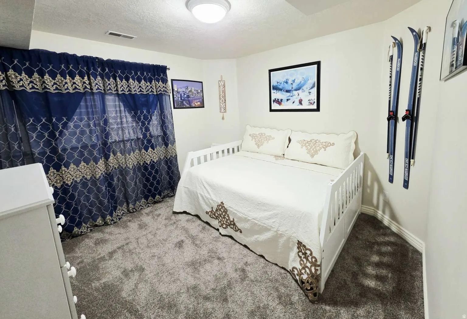 Plush gray carpeting, white painted walls, and a ceiling-mounted light fixture
