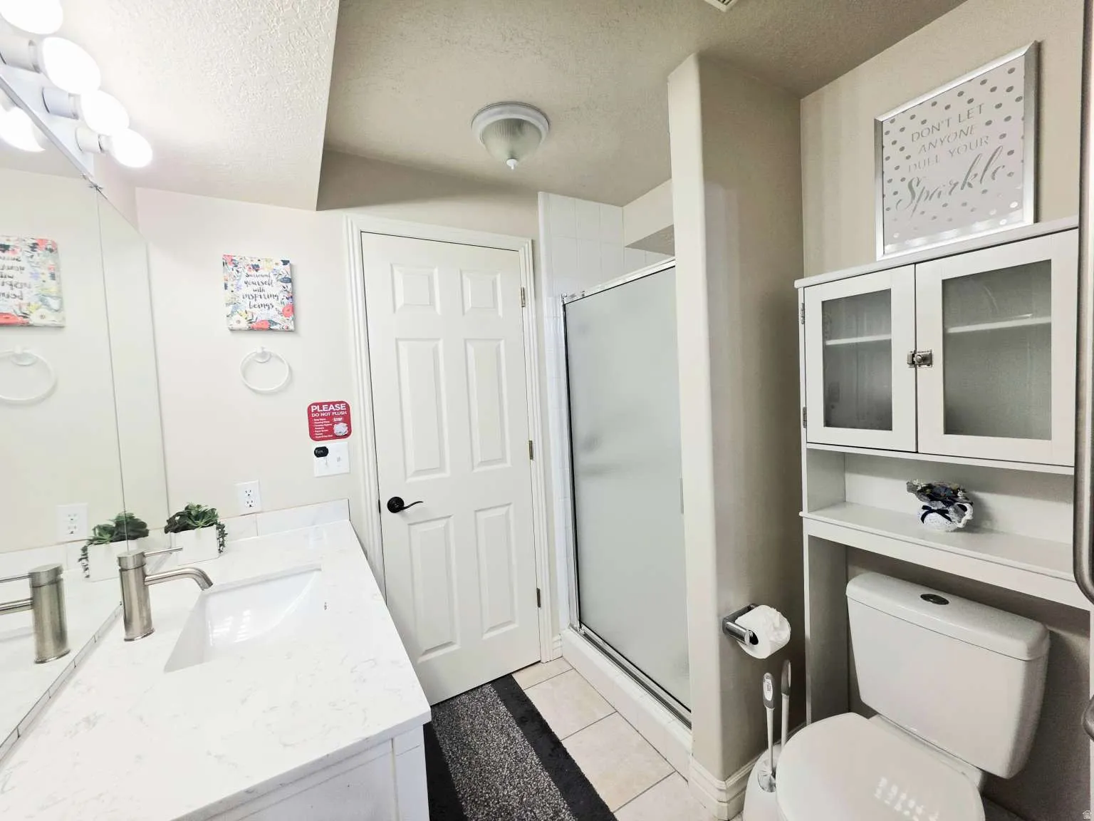 Vanity with white countertop, undermount sink, and brushed nickel faucet