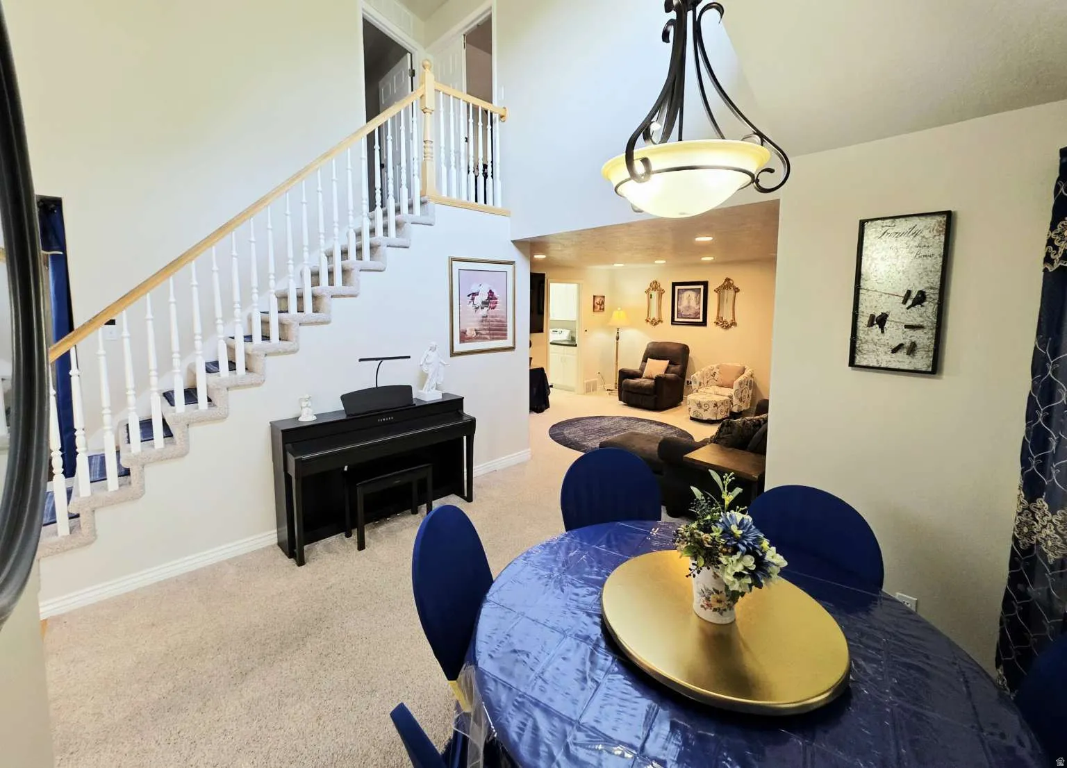 Two-story foyer with a carpeted staircase featuring white balusters and a wood handrail