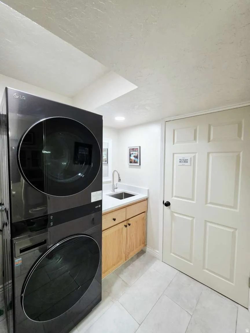 Light wood-finish cabinetry with a white countertop and undermount sink