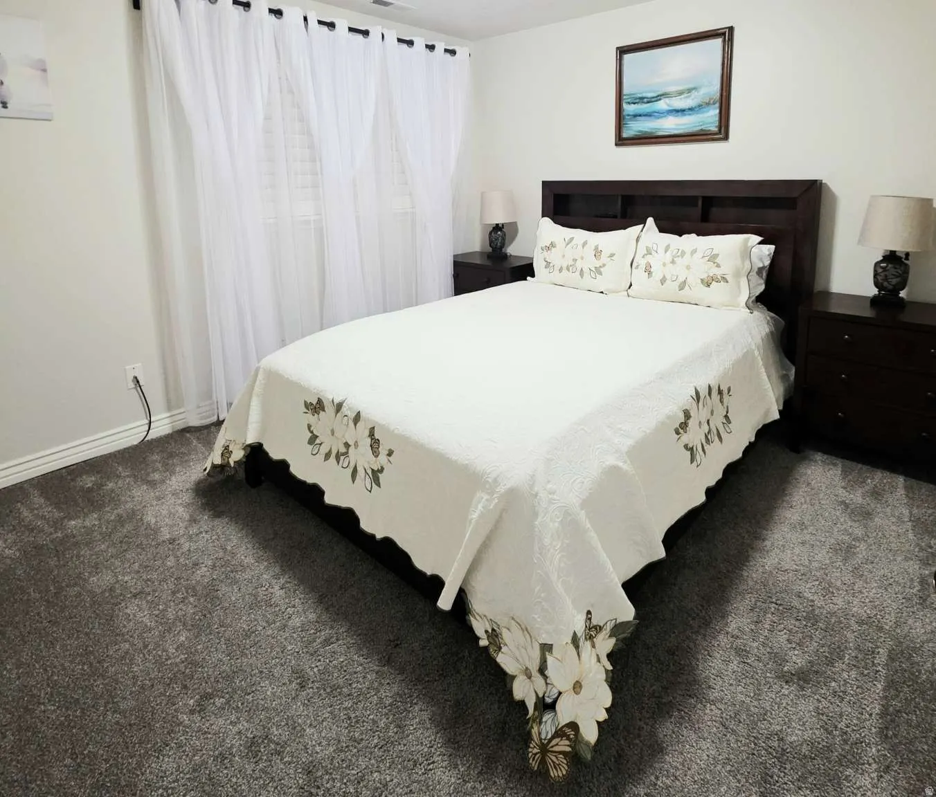 Dark-toned wood-finish bed frame, coordinated nightstands, and dark gray carpeting