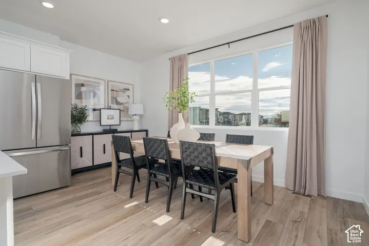 Wood-finish flooring, recessed lighting, and a stainless steel French door refrigerator