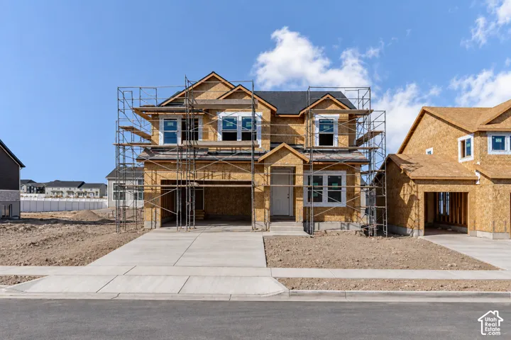 New construction residence under development, featuring a concrete driveway and an attached two-car garage