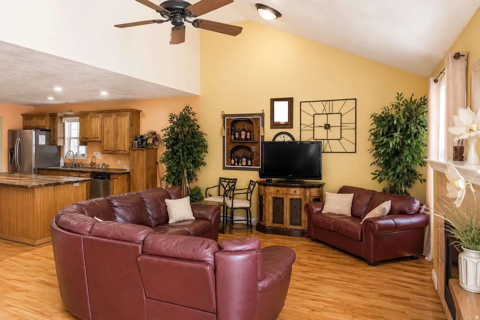 Vaulted ceilings with a ceiling fan, wood-finish flooring, recessed lighting, and a built-in fireplace