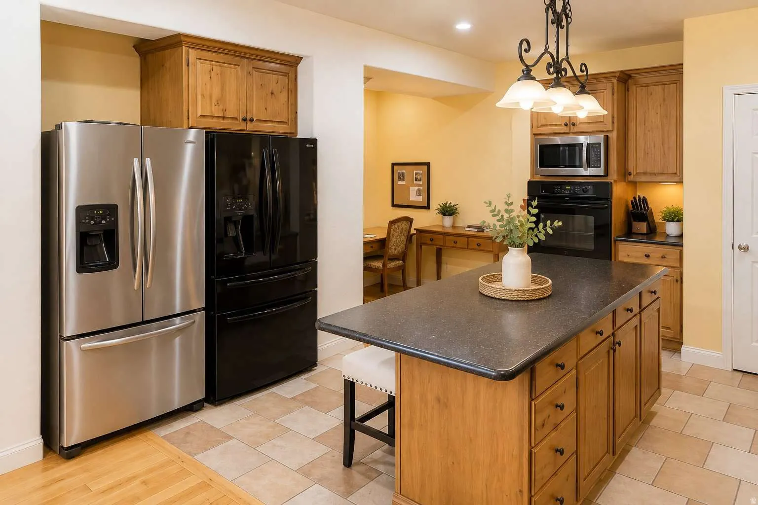 Kitchen featuring a central island with countertop seating, wood cabinetry, stainless steel appliances, and tile flooring