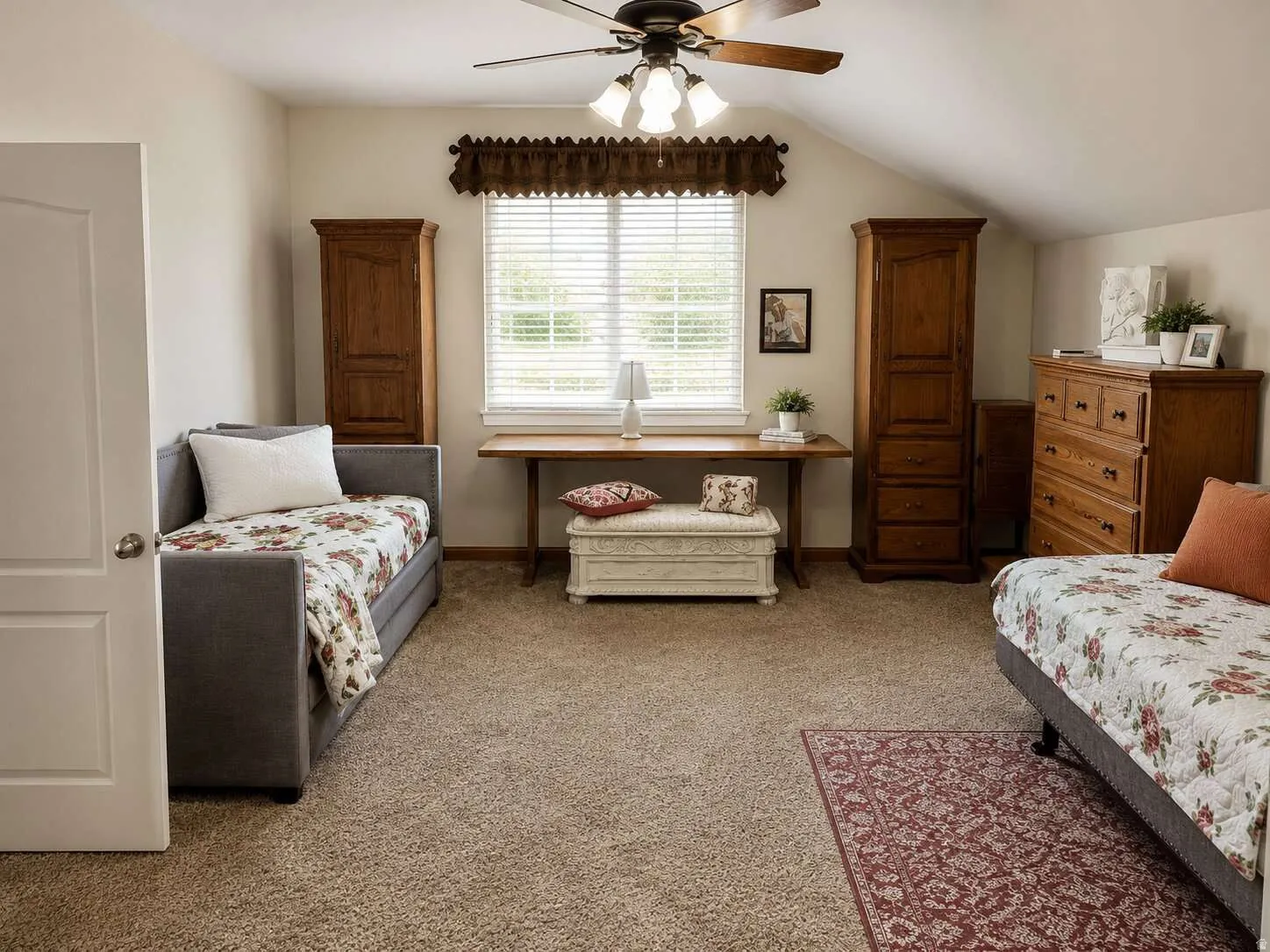 Carpeted flooring, vaulted ceiling, window with blinds, ceiling fan with light fixture, and a solid core door