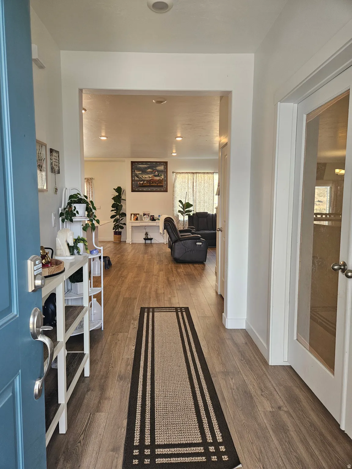 Entryway featuring wood-finish flooring, white walls, and recessed lighting