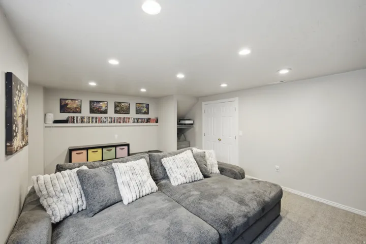 Recessed ceiling lighting, light gray wall paint, built-in shelving, carpet flooring, and a white paneled door