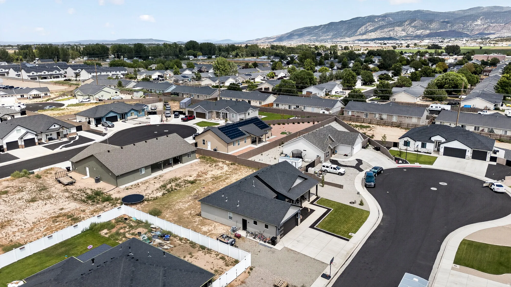 Cul-de-sac location with paved street, concrete sidewalks, and an open lot