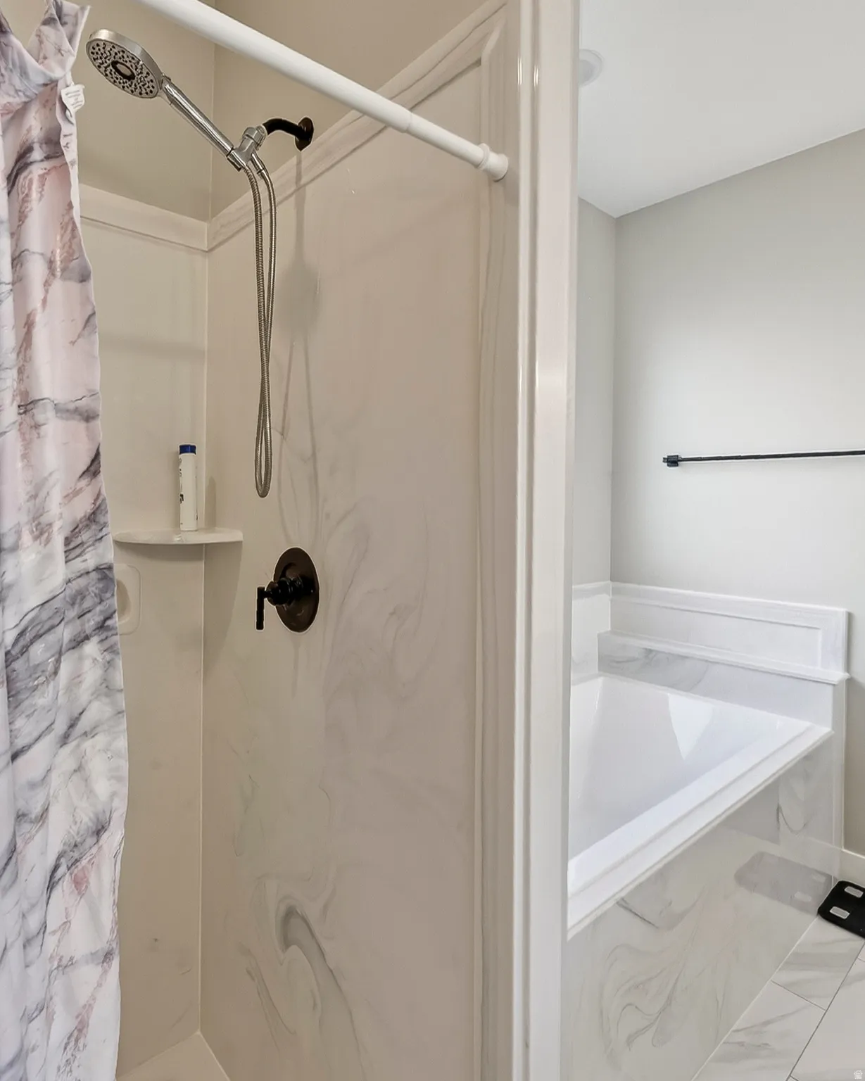 Walk-in shower with a handheld showerhead and bronze fixtures