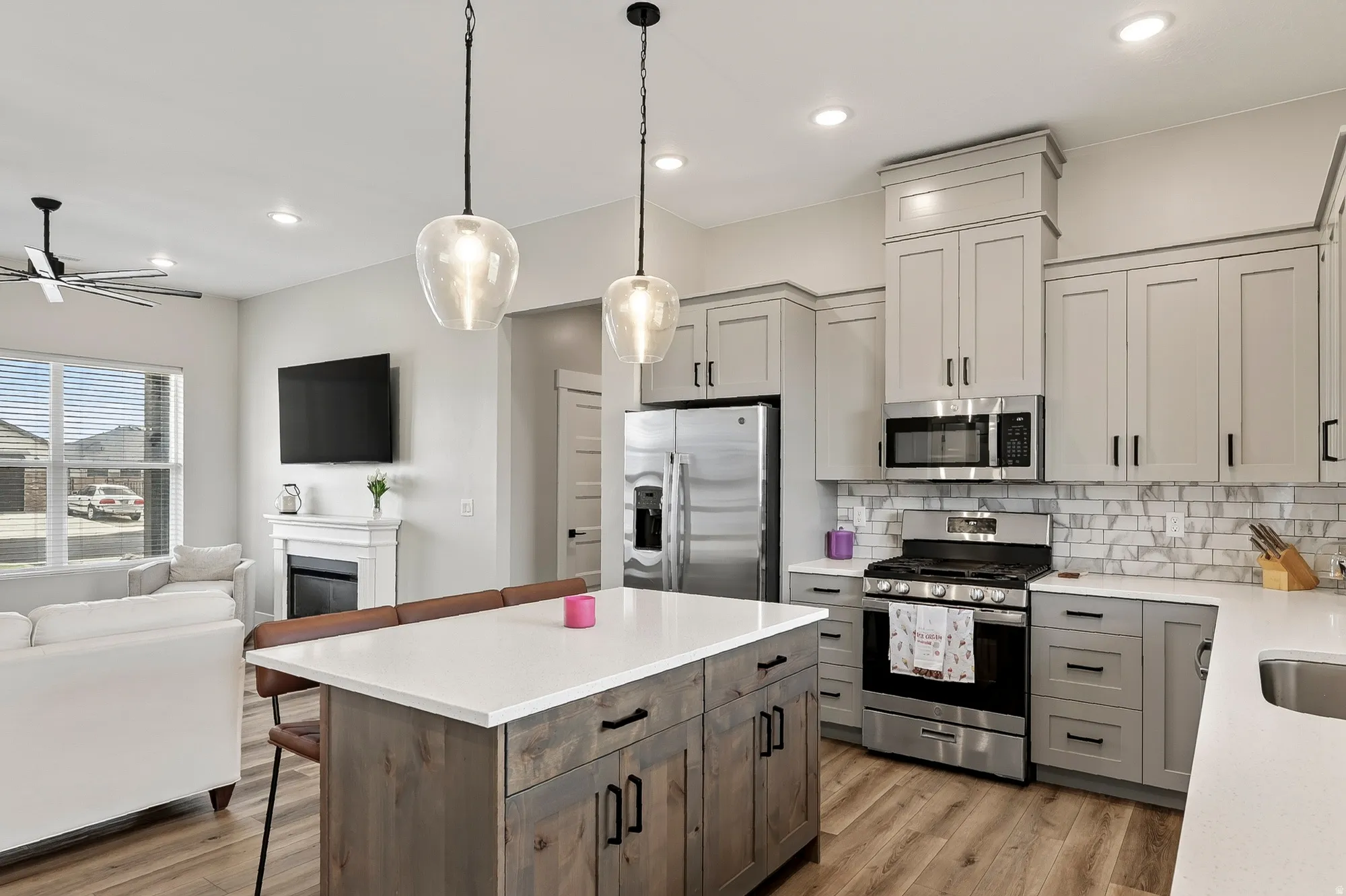 Open-concept kitchen featuring an island with a white countertop, recessed lighting, and stainless steel appliances