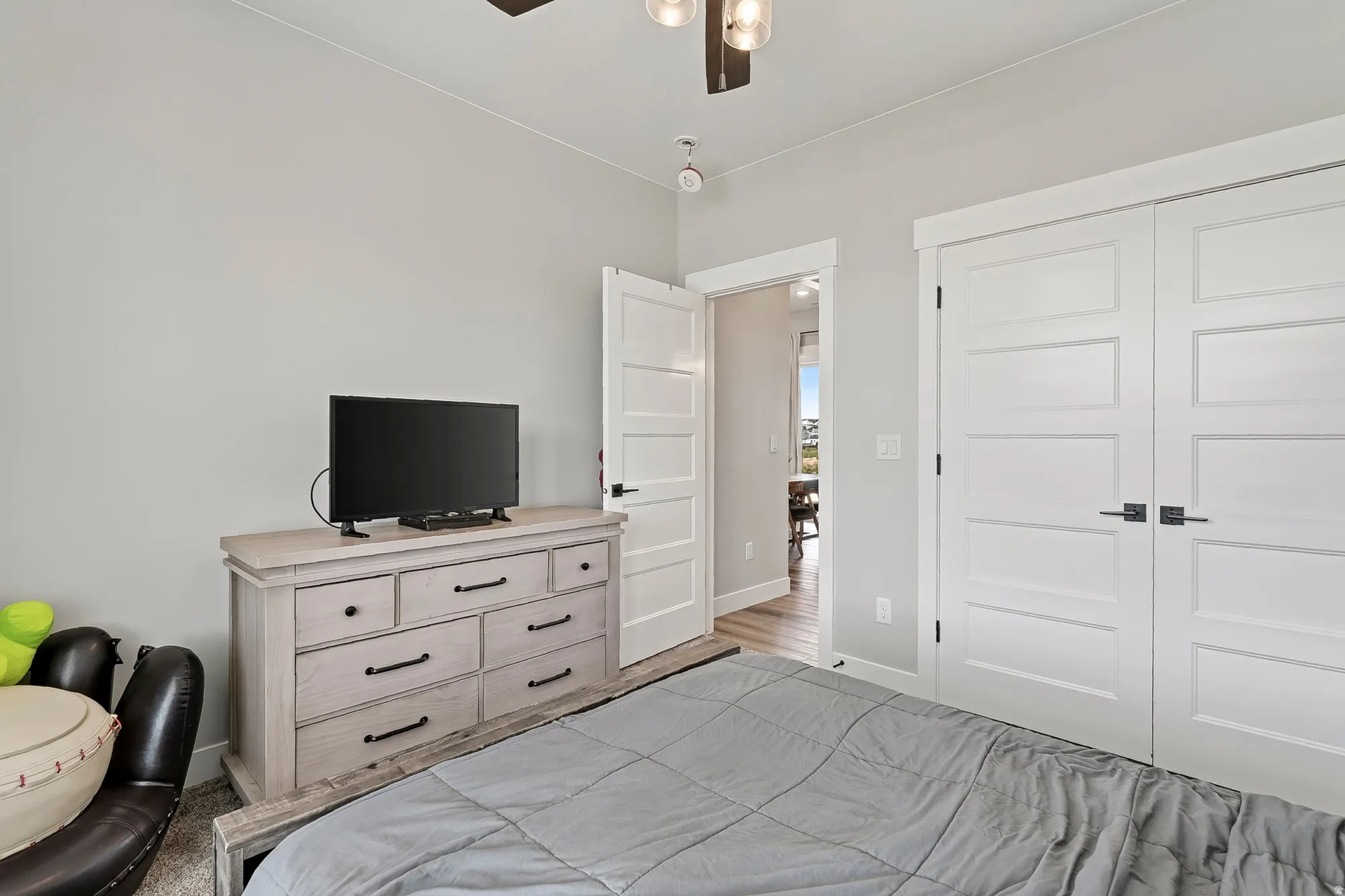 Light gray walls, white trim, and a ceiling fan with integrated lighting