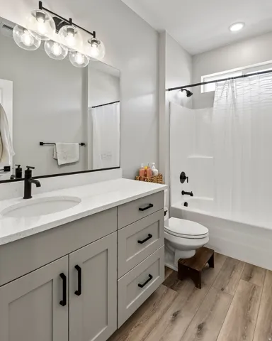 Light gray vanity with black hardware, white countertop, and integrated sink