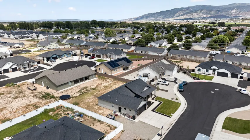 Cul-de-sac location with paved street, concrete sidewalks, and an open lot