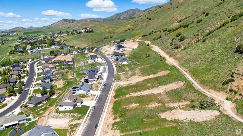 New construction residences situated within a developed community featuring paved roads and mountain backdrops