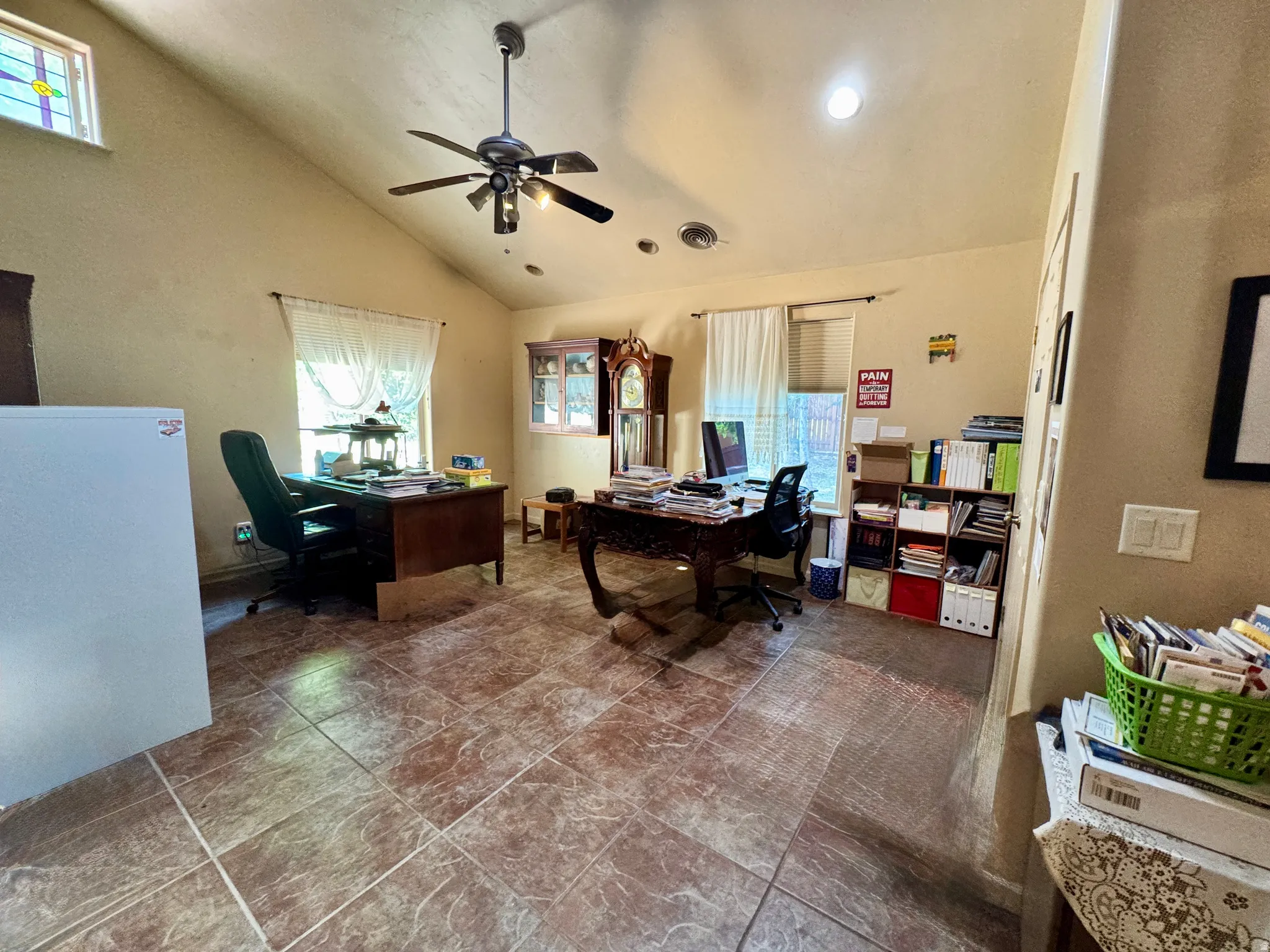 Vaulted ceiling with a ceiling fan, recessed lighting, tiled flooring, and multiple windows with natural light