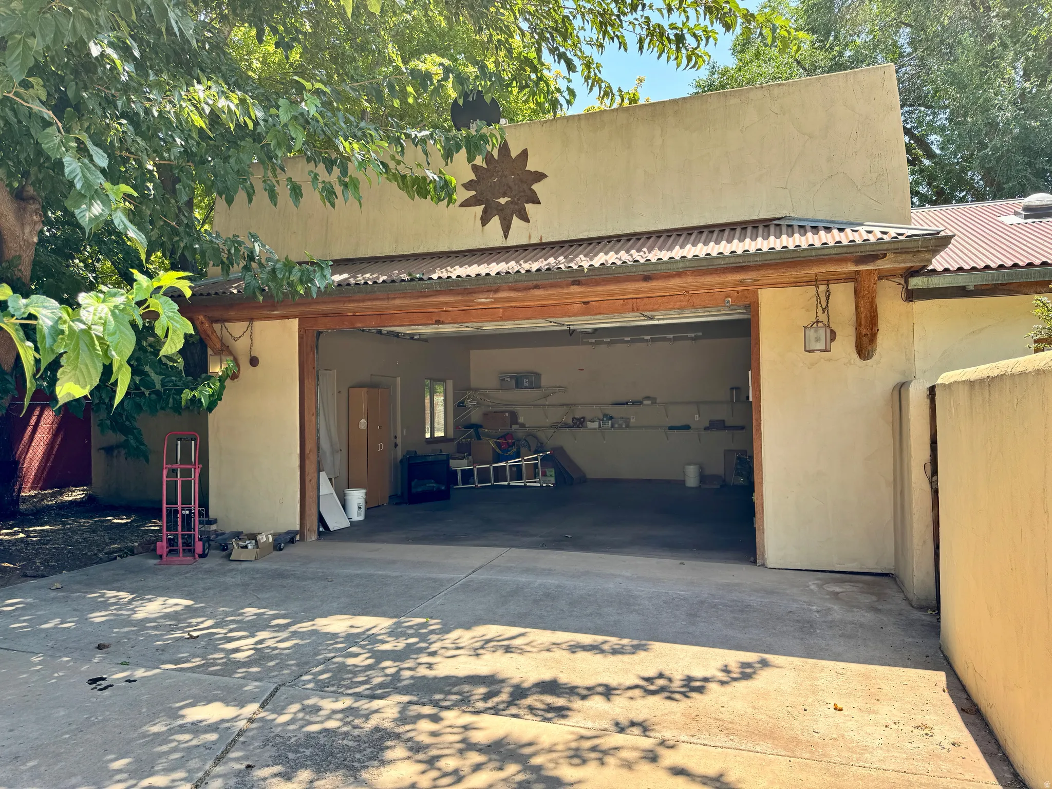 Concrete driveway leading to a two-car garage with a corrugated metal roof