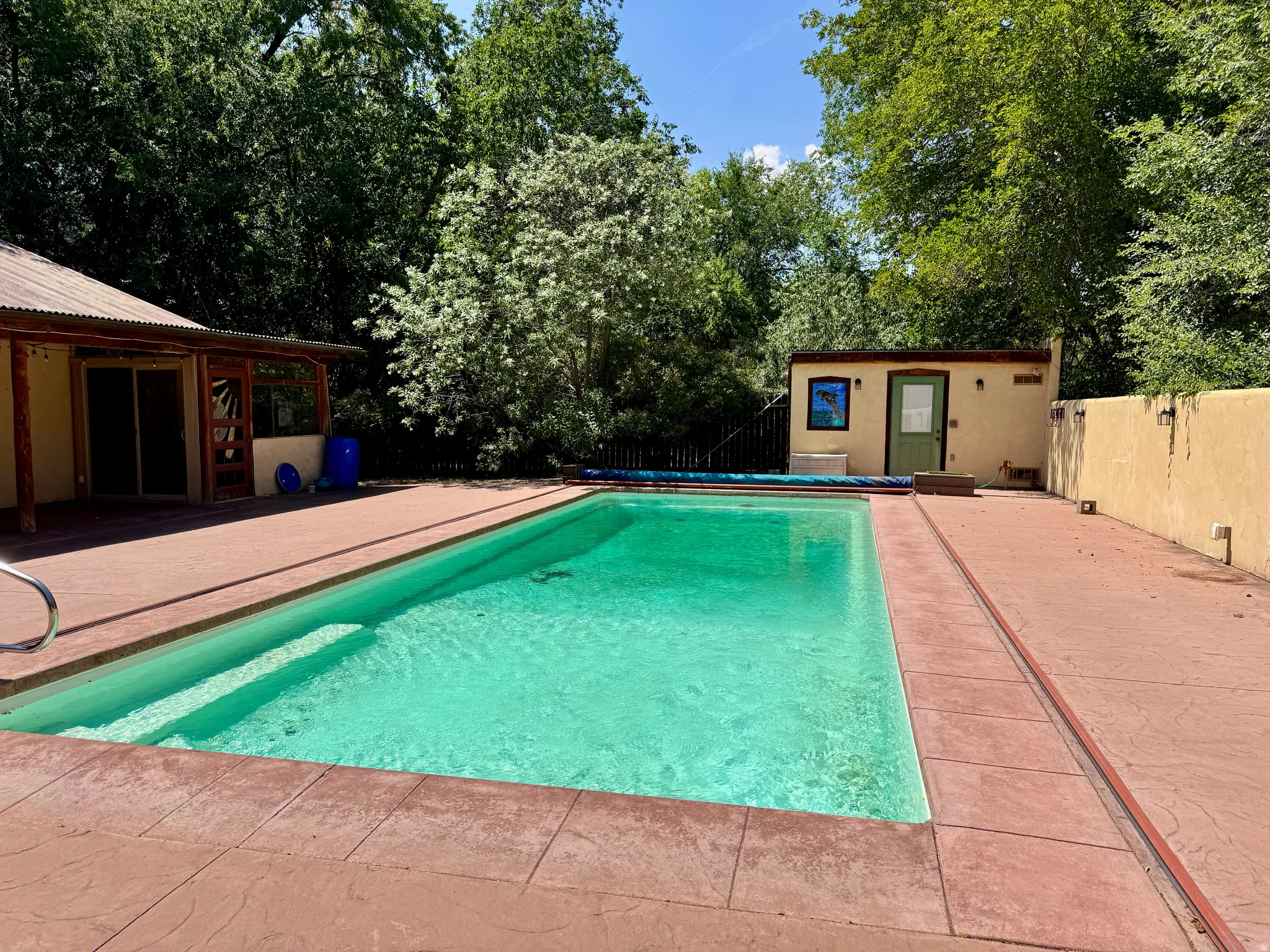 Expansive outdoor pool with integrated steps, surrounded by stamped concrete decking