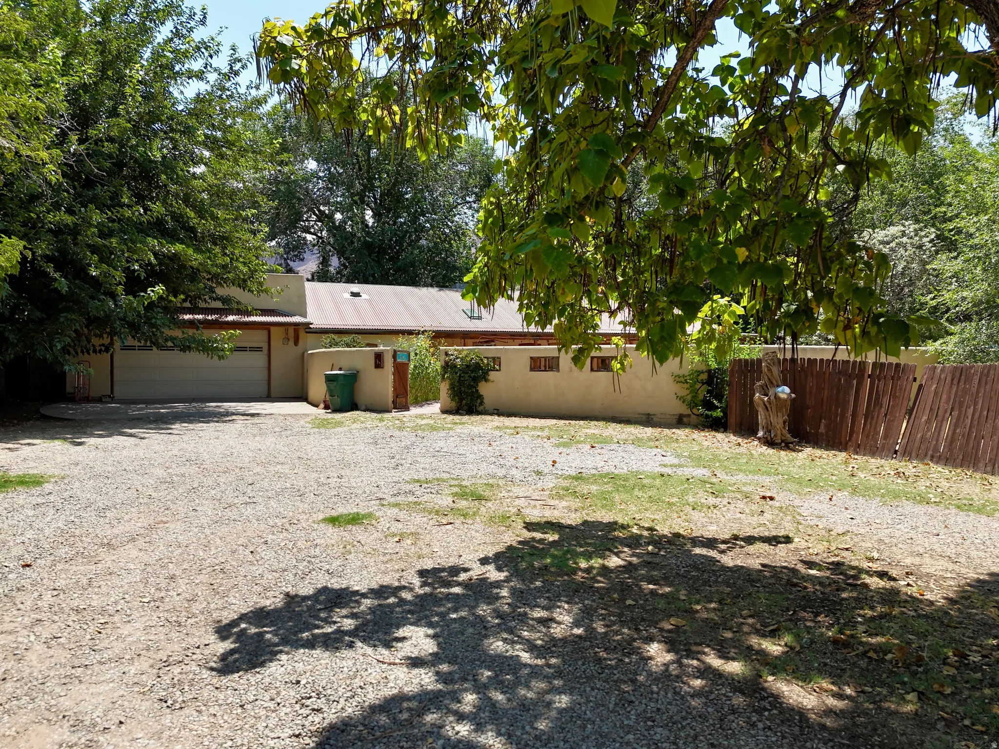 Stucco exterior with a metal roof and an attached garage