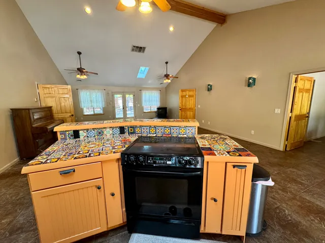 Vaulted ceilings, exposed wood beam, skylight, and recessed lighting