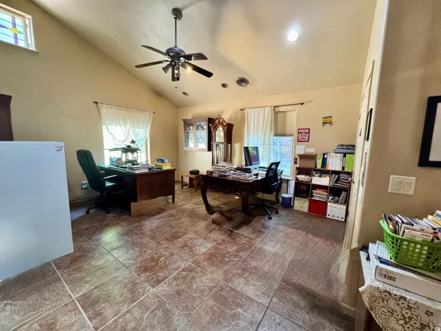 Vaulted ceiling with a ceiling fan, recessed lighting, tiled flooring, and multiple windows with natural light