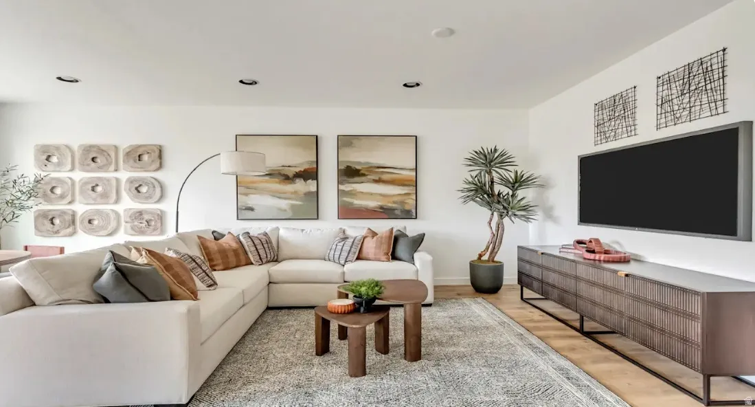 Recessed lighting illuminates the open living space with light-toned wood-finish flooring. This home is under construction. Pictures are of a similar home.