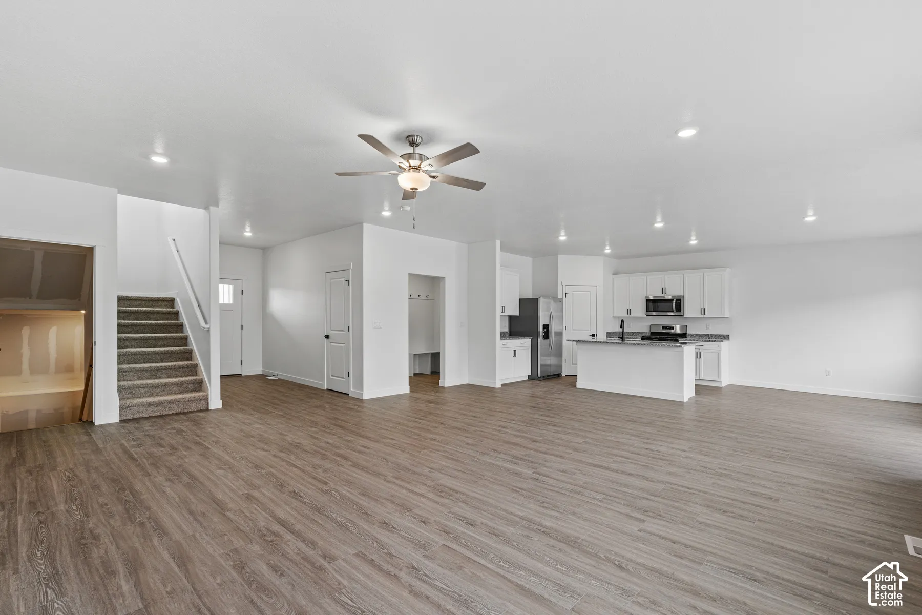Open-concept living area featuring wood-finish flooring, recessed lighting, and a ceiling fan