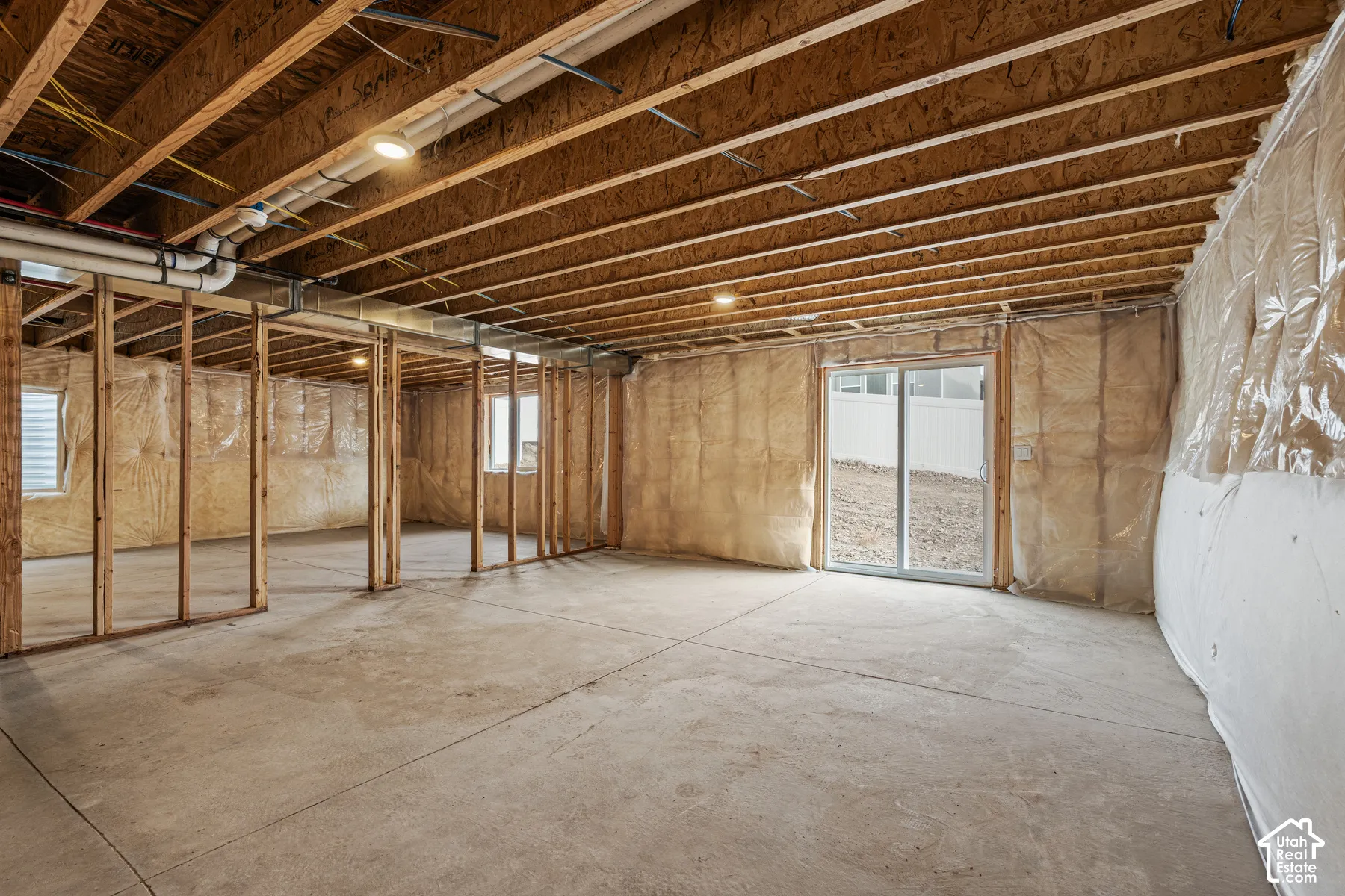 Unfinished basement with concrete flooring and exposed ceiling joists