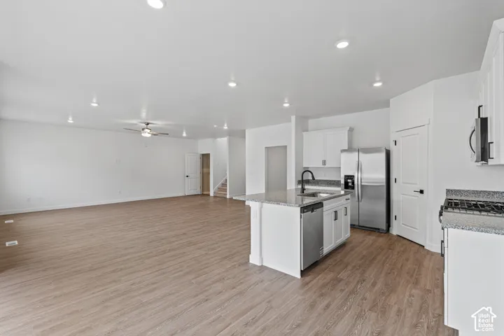 Open-concept living space featuring wood-finish flooring, recessed lighting, and a ceiling fan