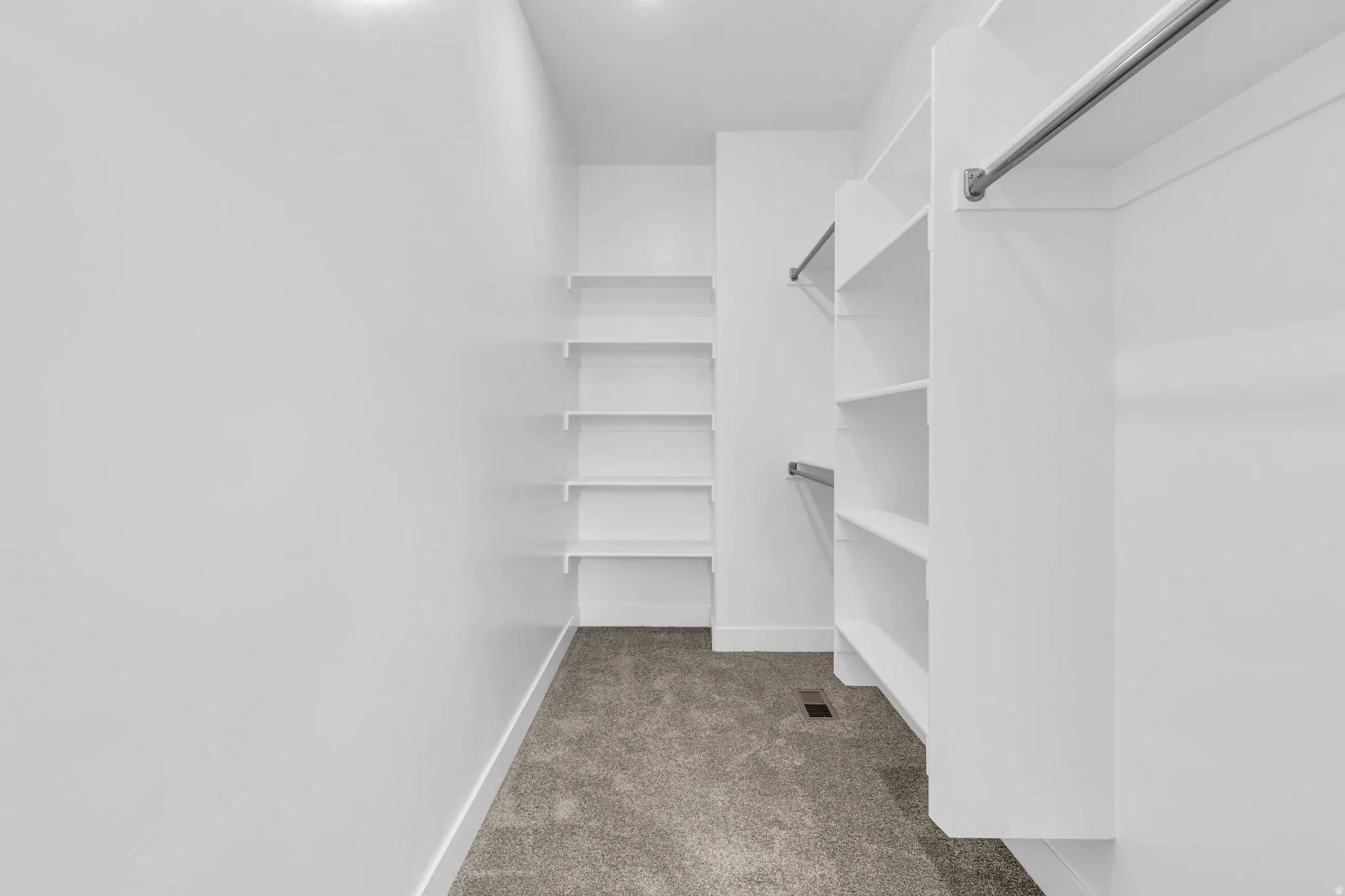 Recessed lighting, built-in shelving, carpet flooring, and clothing rods