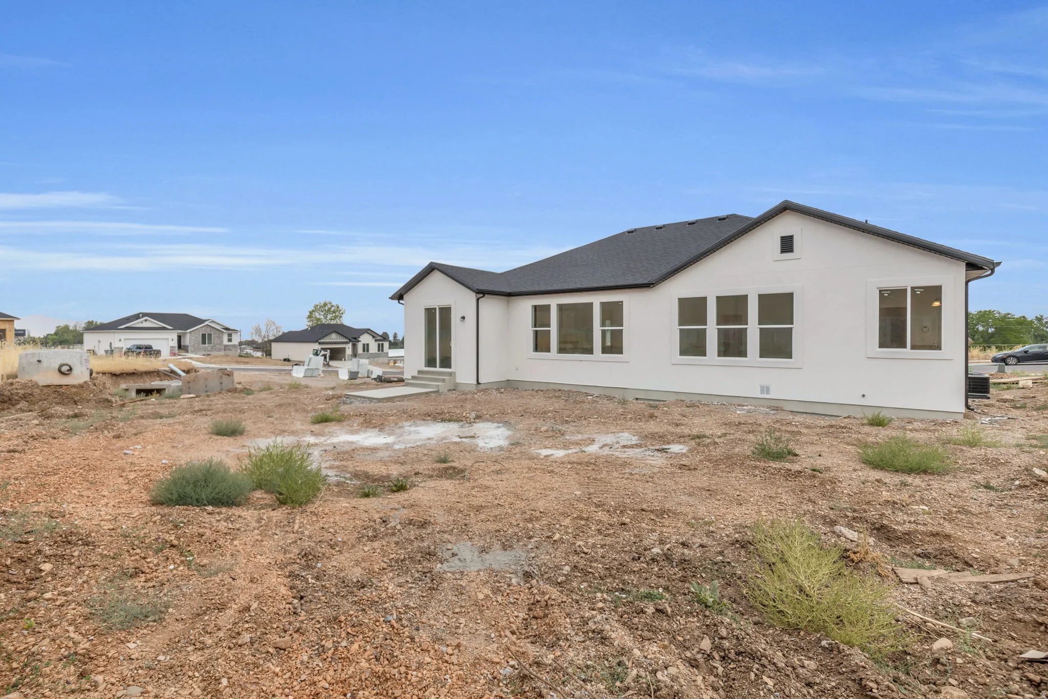 White stucco exterior with a dark asphalt shingle roof